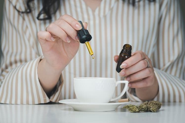 mains de femme qui versent du cbd dans une tasse