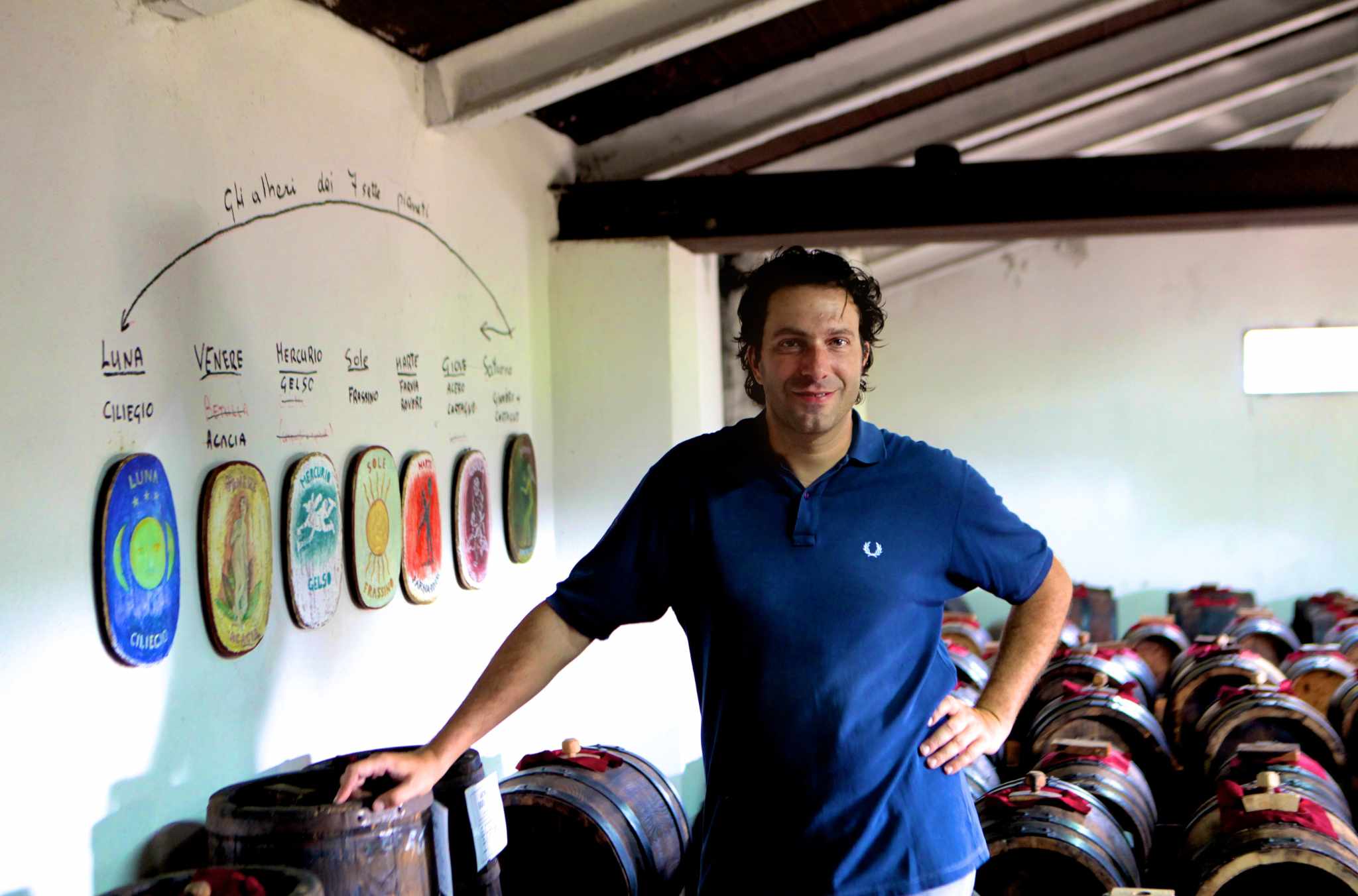 Lorenzo Guerzoni stands in a room next to the barrels used to age his balsamic vinegar.