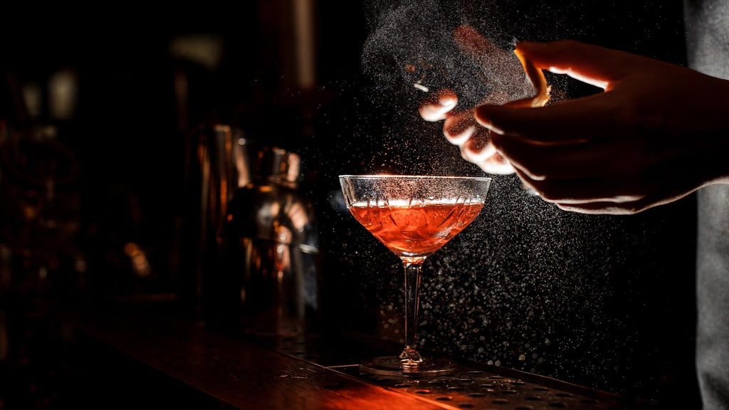 Cocktail Close Up Bartender Sprays Orange Peel Into Glass
