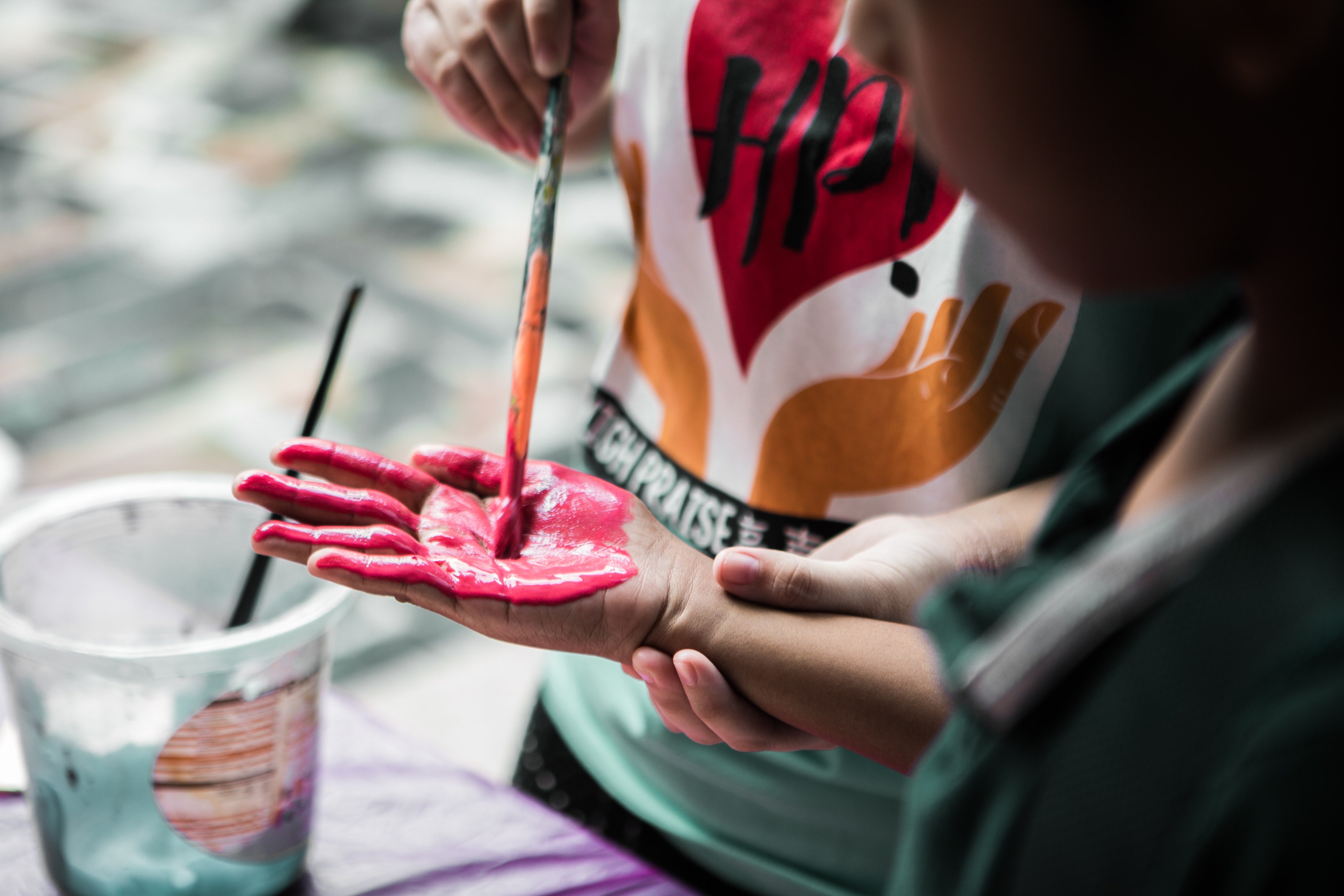 Adult painting kids hand, for turkey handprint art