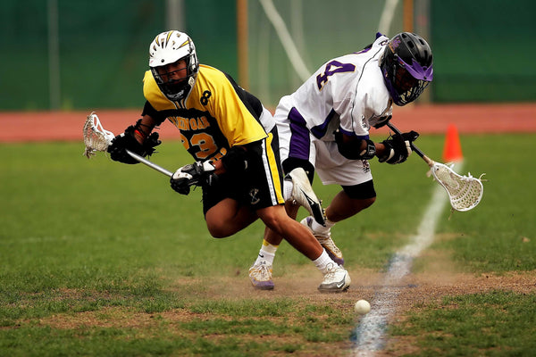 two people playing lacrosse