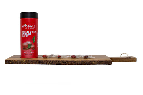 mberry freeze dried miracle berries on a wooden board with the miracle fruit lined up on the right of the packaging