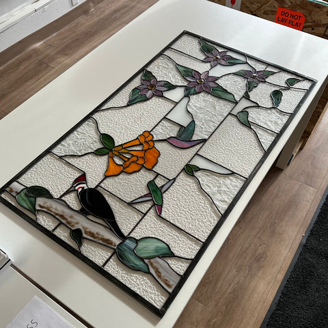 Finished stained glass of birds and flowers.