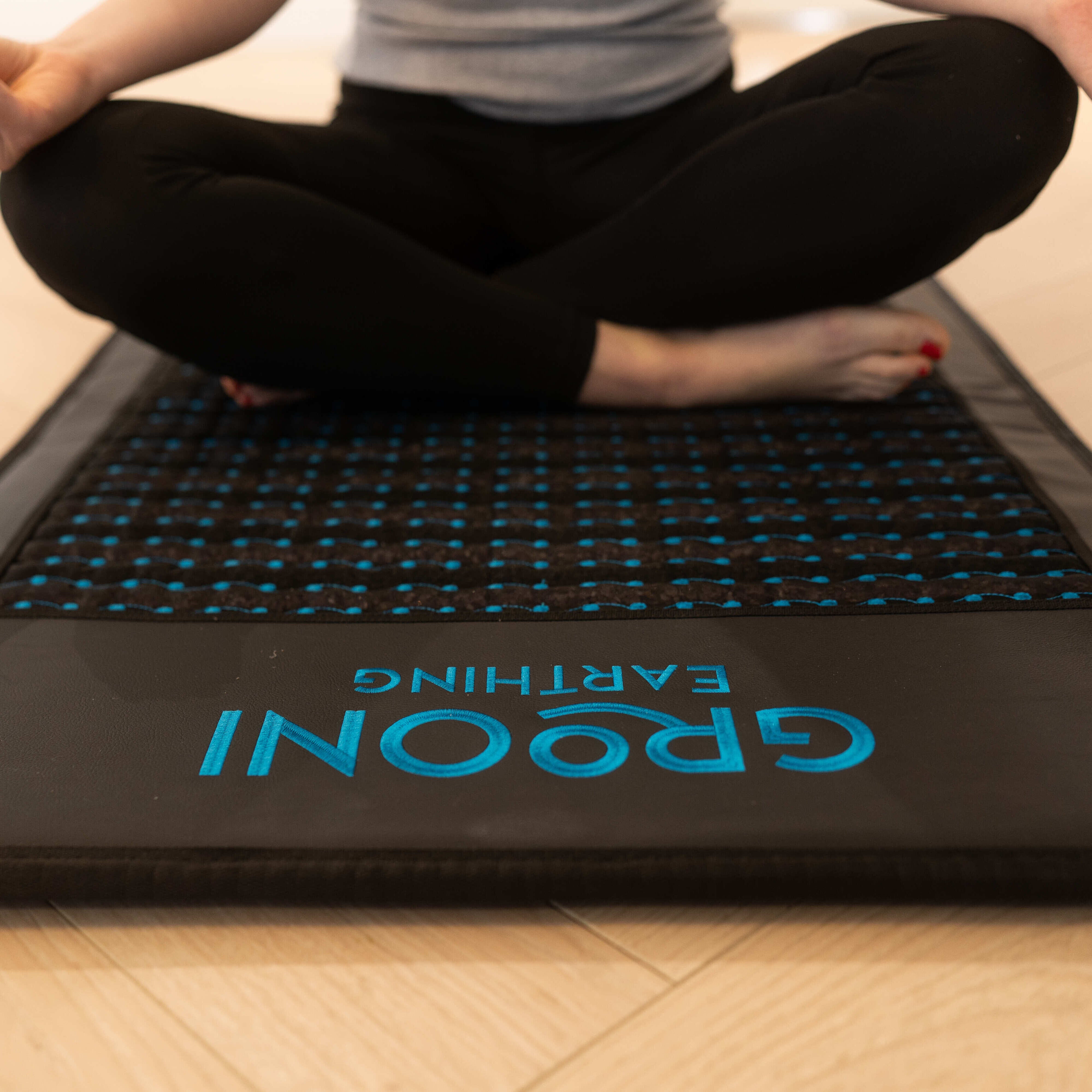 Woman over PEMF mat in a meditation pose
