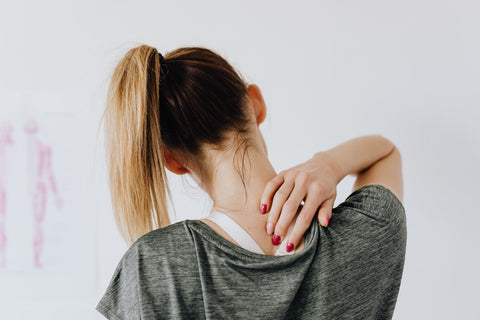 woman touching back of her neck