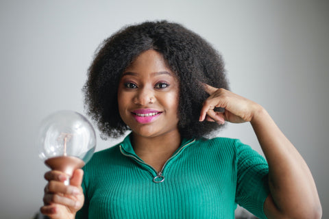 smiling woman holding lightbulb