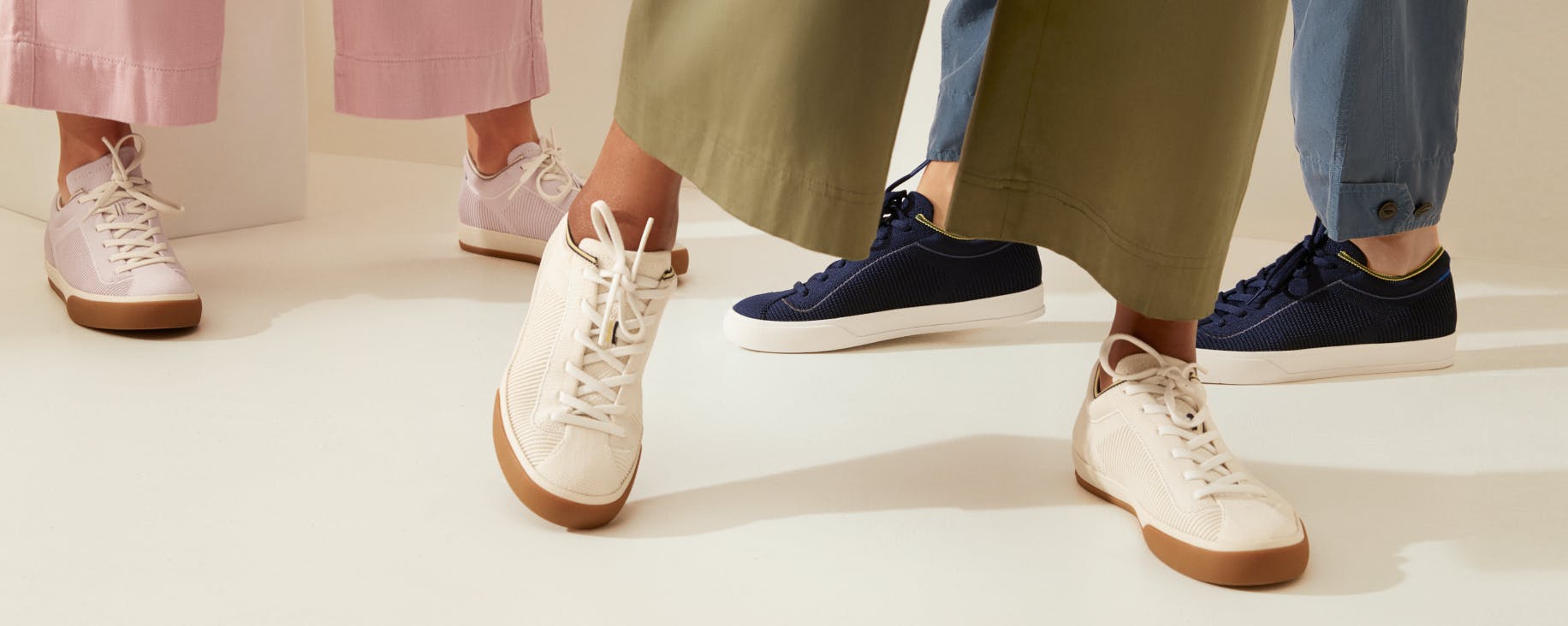 The Lace Up in Lilac, The Lace Up in Vanilla and The Lace Up in Navy shown on the feet of three models. 