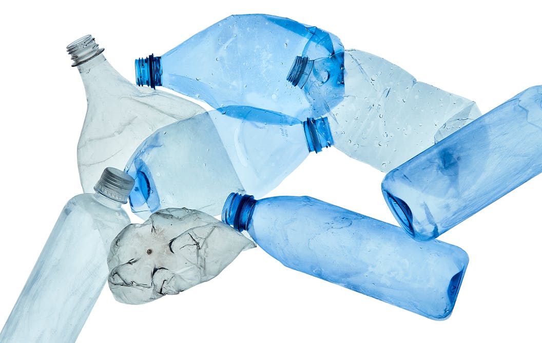 Close up of flattened blue and grey plastic bottles. 