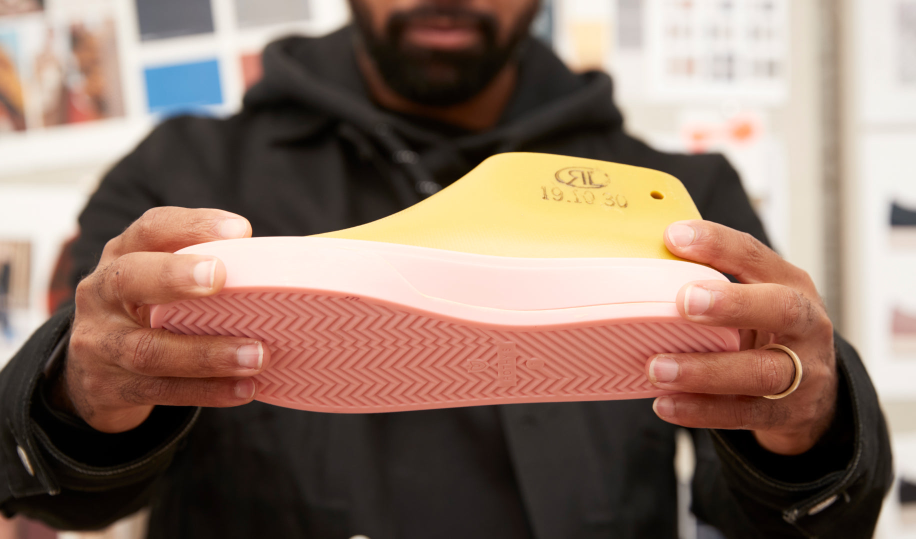 Close up of Lavion holding up a shoe prototype. 