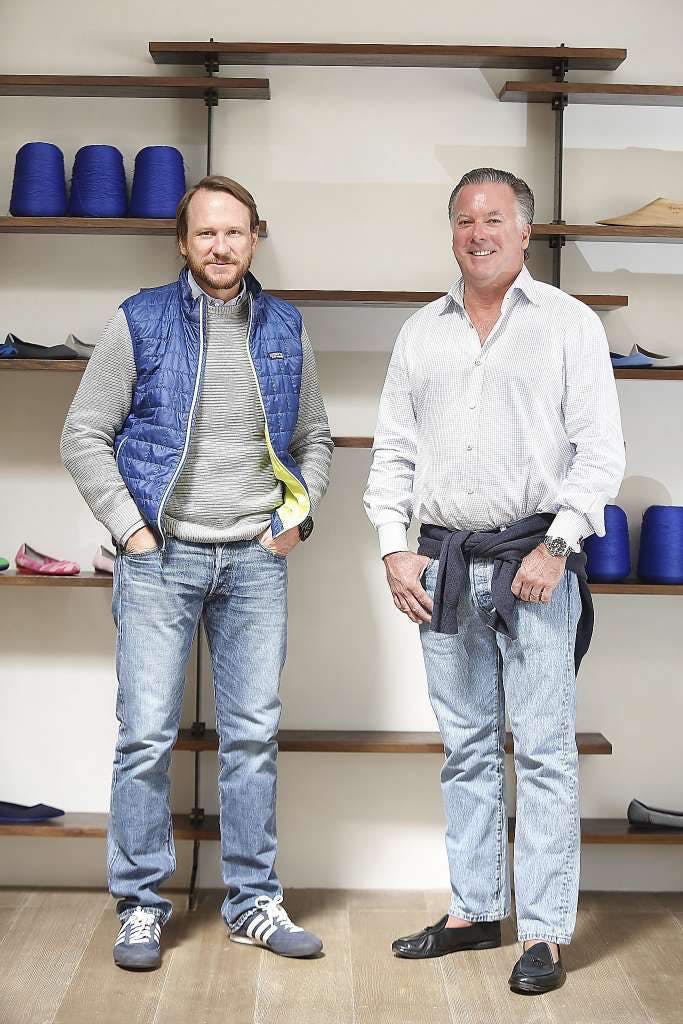 Co-founders of Rothy's Roth Martin and Stephen Hawthornthwaite, standing in front of shelves with spools of thread and shoes upon them.