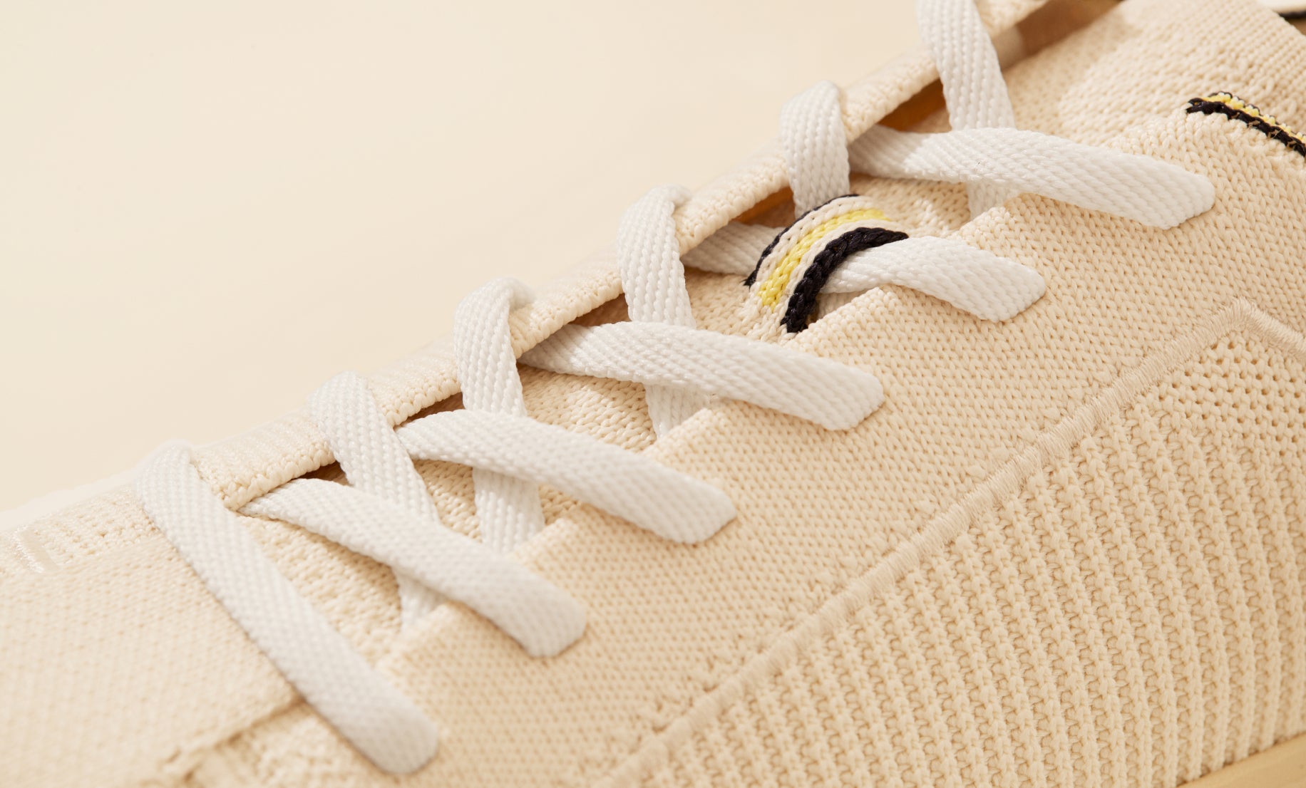 Close up of the laces of The Lace Up in Vanilla, showing the striped navy, yellow and white lace stay detail.  