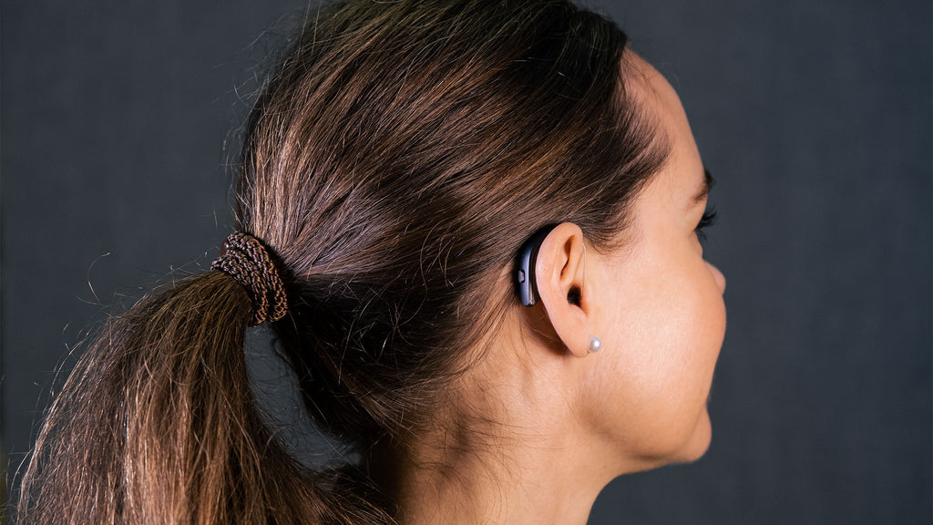 A young adult wearing a resound hearing aid.
