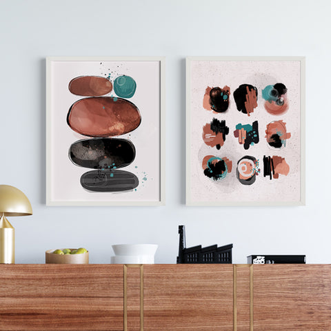 2 abstract paintings hanging on a wall in front of a console table