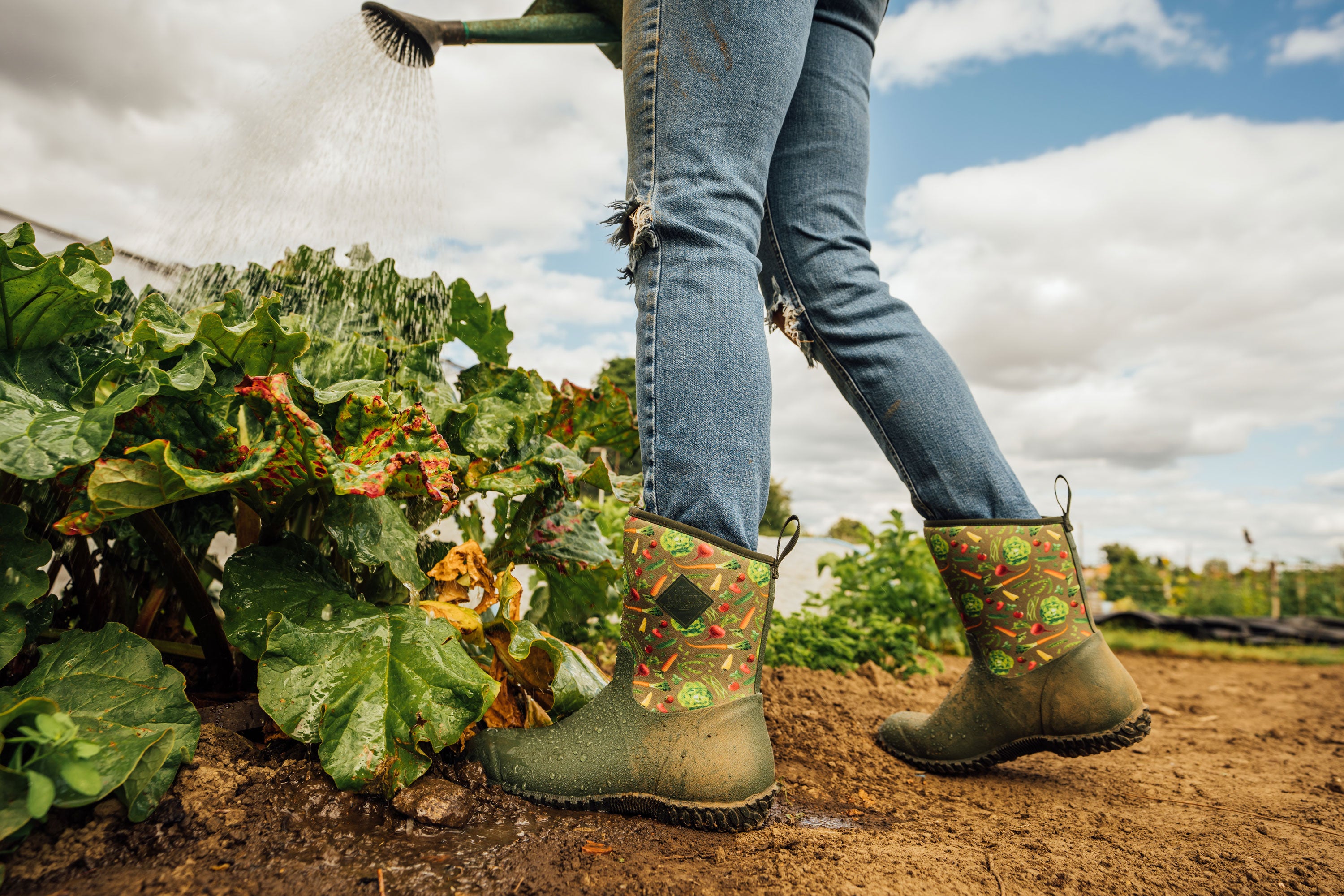 Person in RHS Muckster II Short Boots watering plants