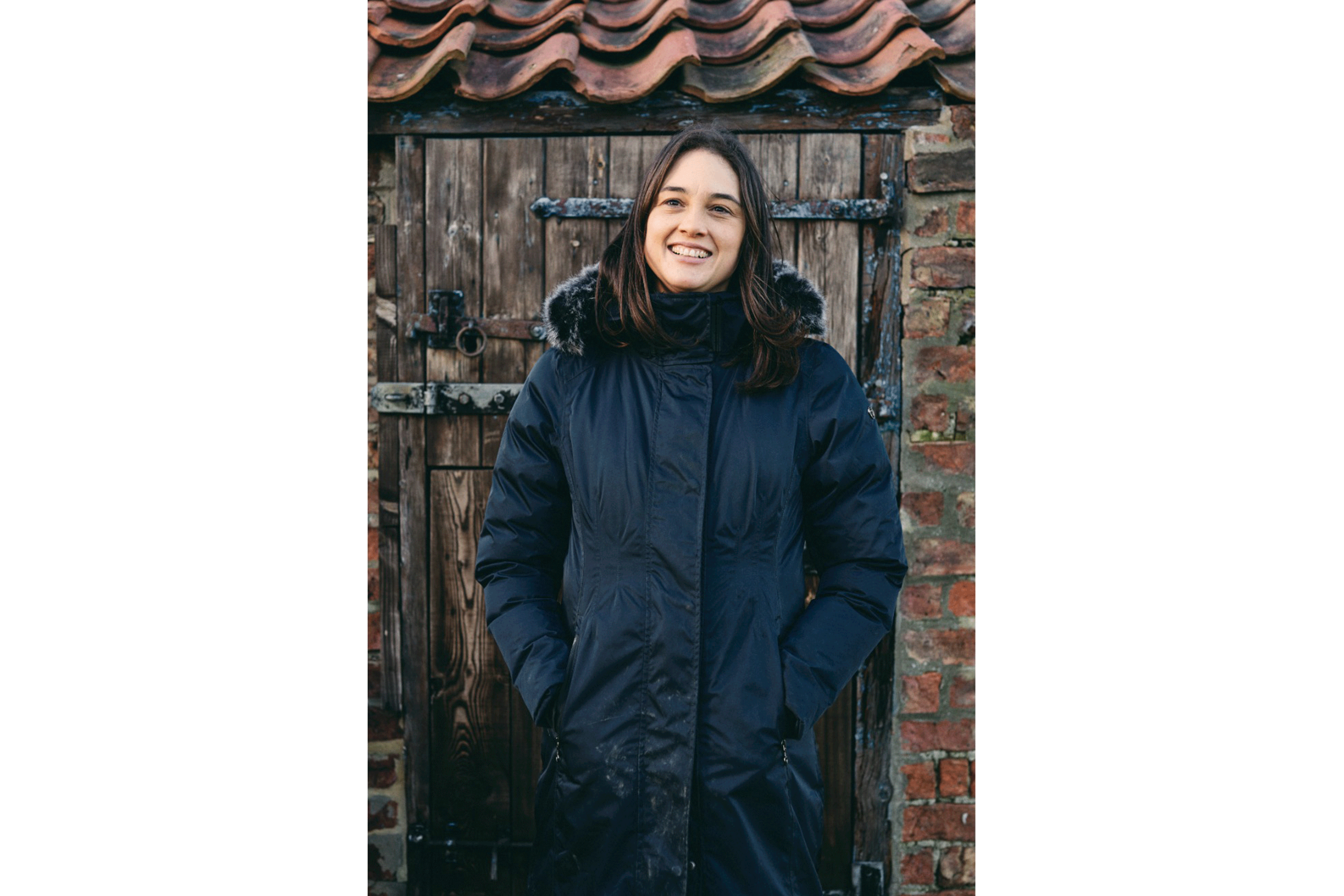 Paula Drury standing in front of a horse stable.