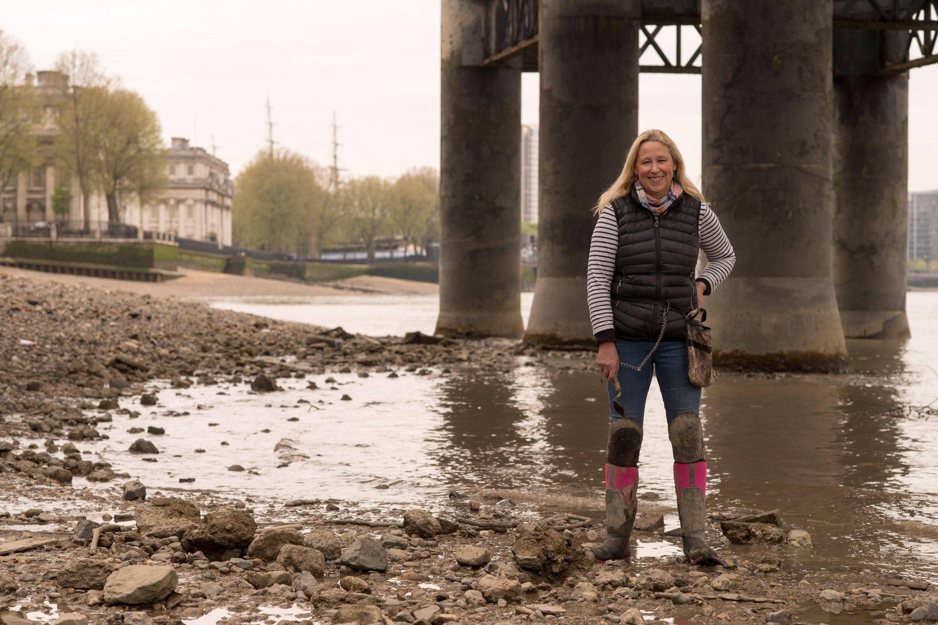 Nicola White stood on the muddy Thames shore, underneath a bridge