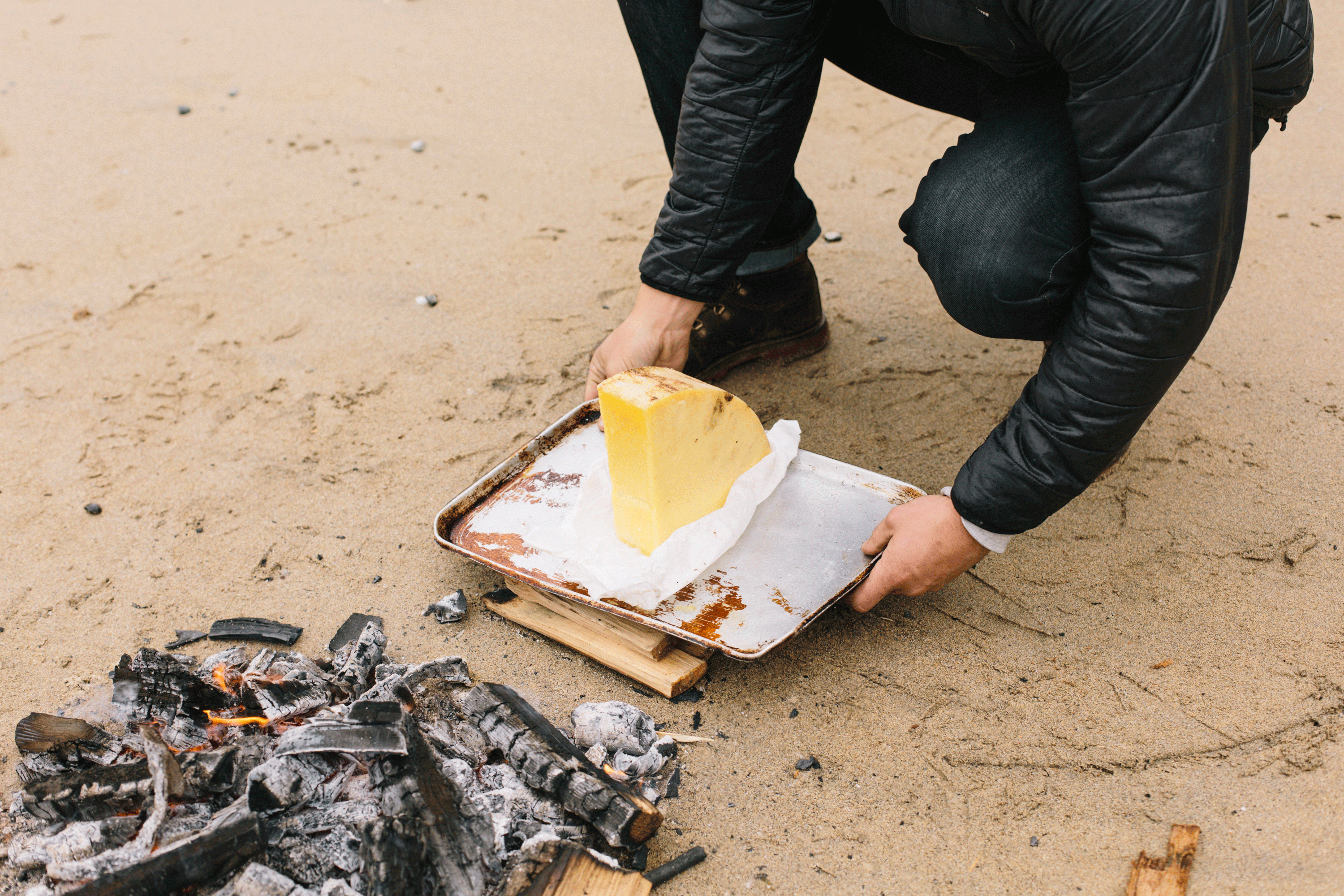 Getting a block of cheese ready next to the fire.