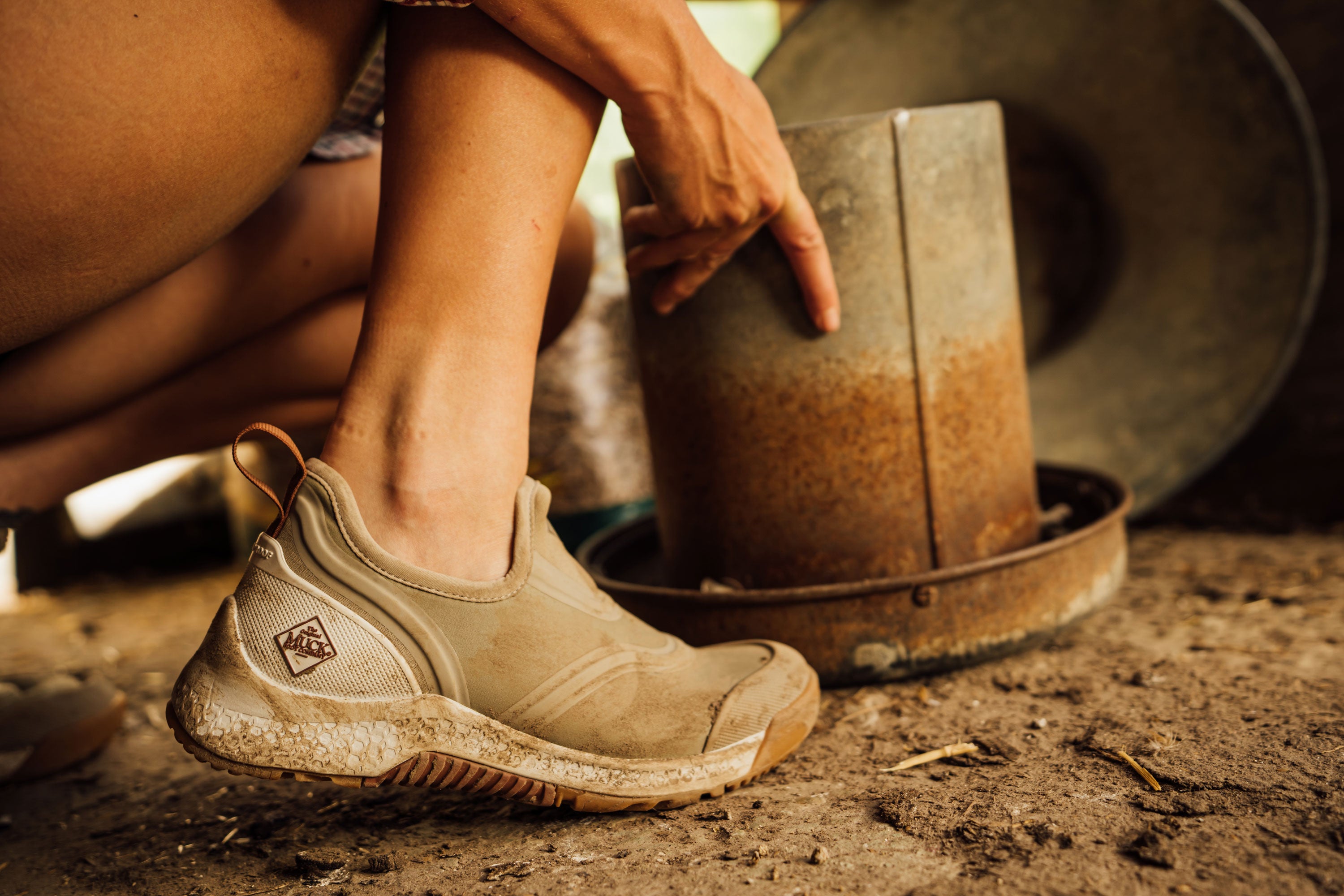 Person crouching down touching rusty metal parts