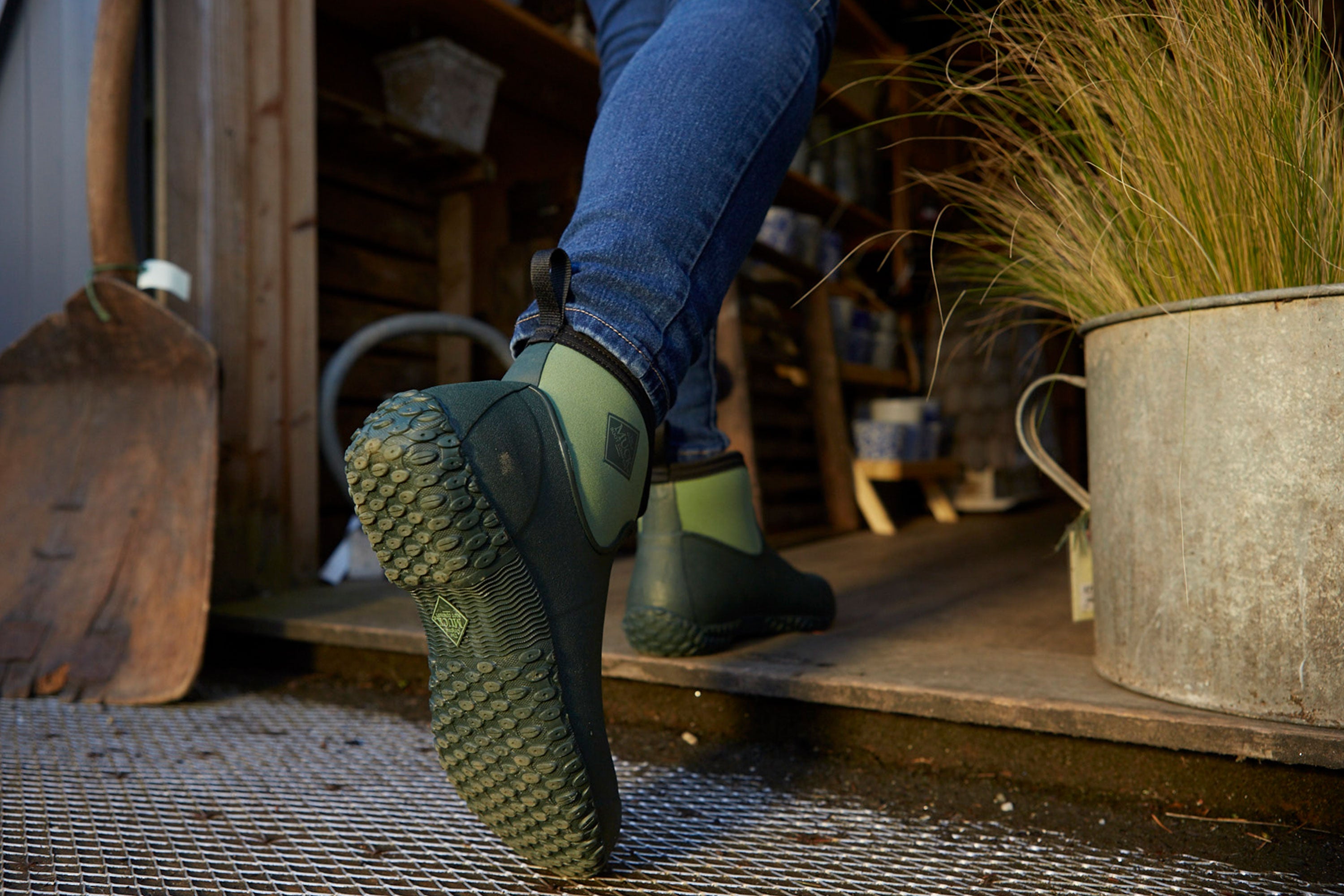 Person walking into a shed wearing a pair of Muckster II Boots