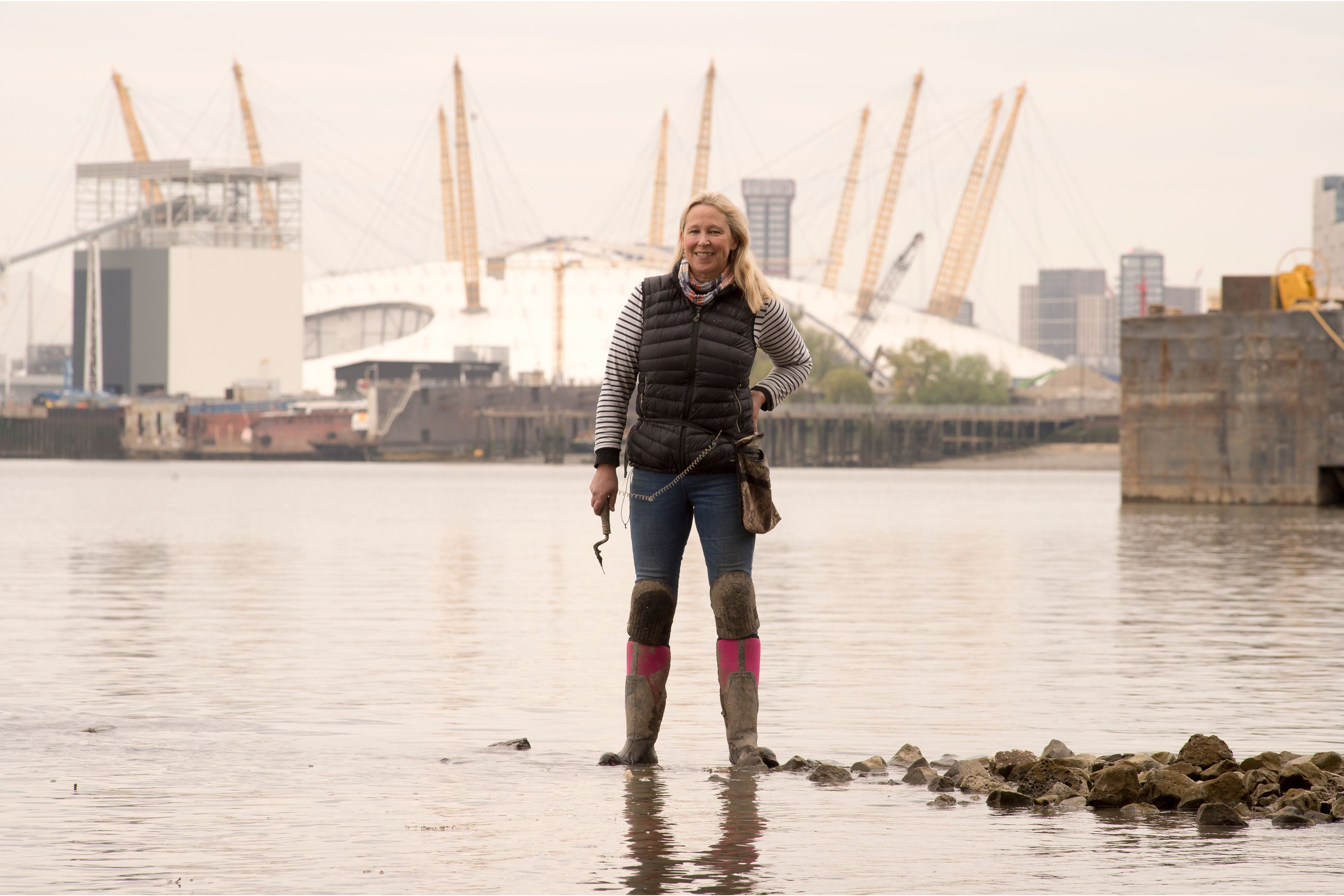 Nicola standing in a pair of Arctic Sport II Tall Boots in hot pink with the O2 Arena behind her