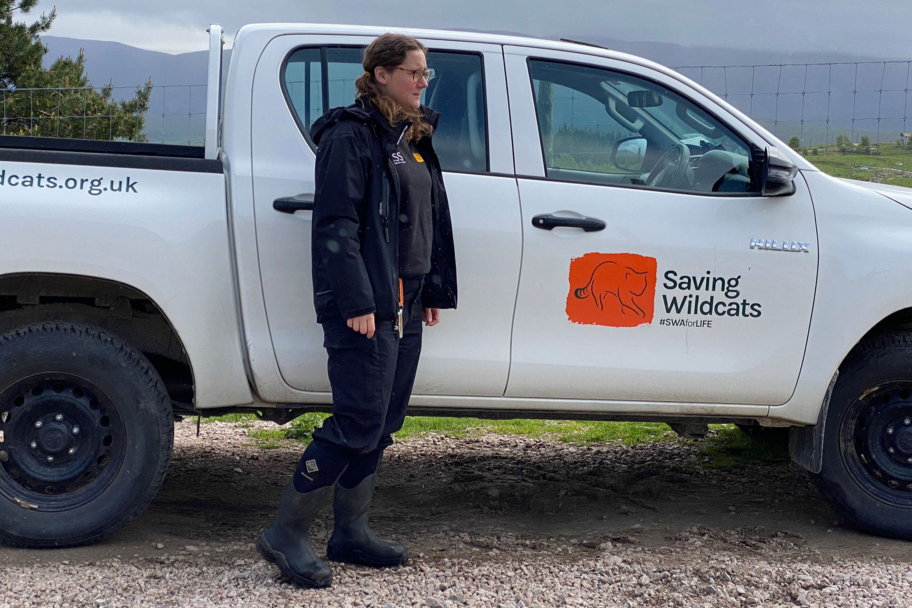 Rachel standing outside her ranger truck wearing a pair of Muck Boots