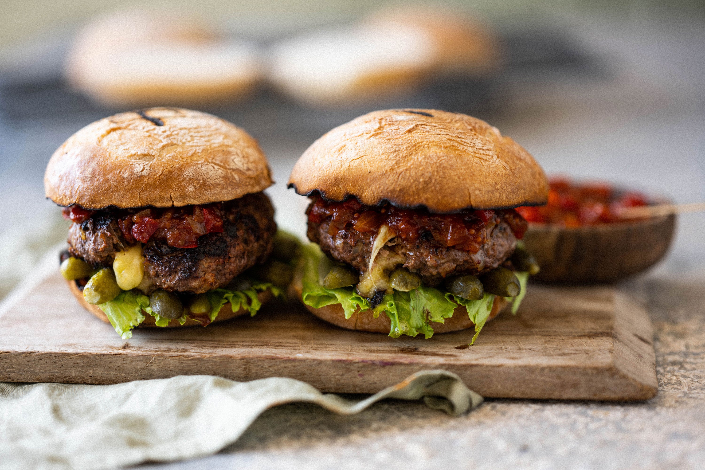 Finished burgers served on a wooden board