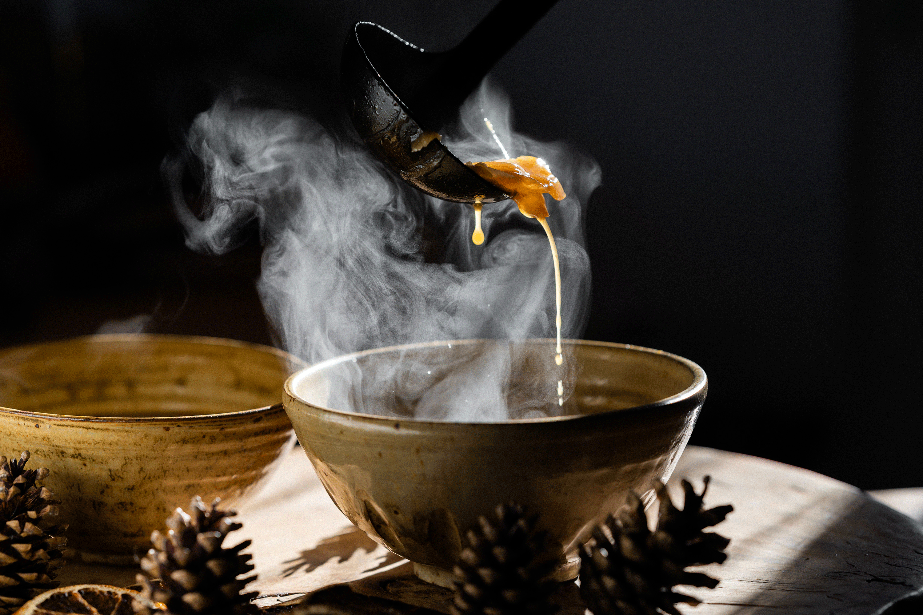 Caramelised onions served into a steaming bowl with a ladle.  