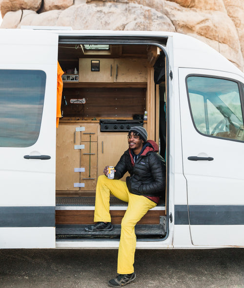 Nate Pierce holding Mango flavored sparkling hop water in front of white van