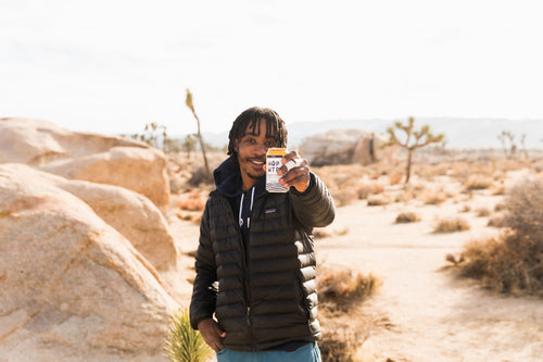 Nate Pierce Holding Mango flavored sparkling hop water out at Joshua tree national park