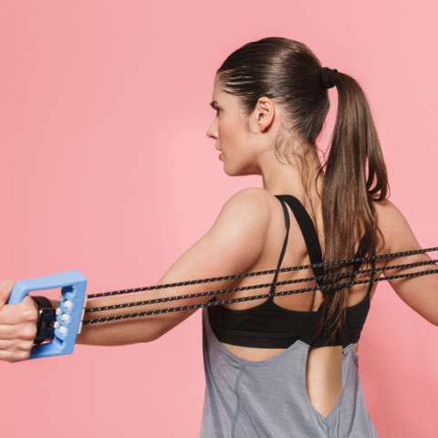 woman exercising on pink background