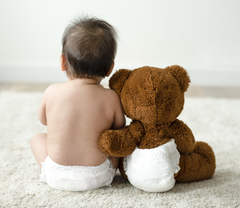 baby and teddy bear in diapers