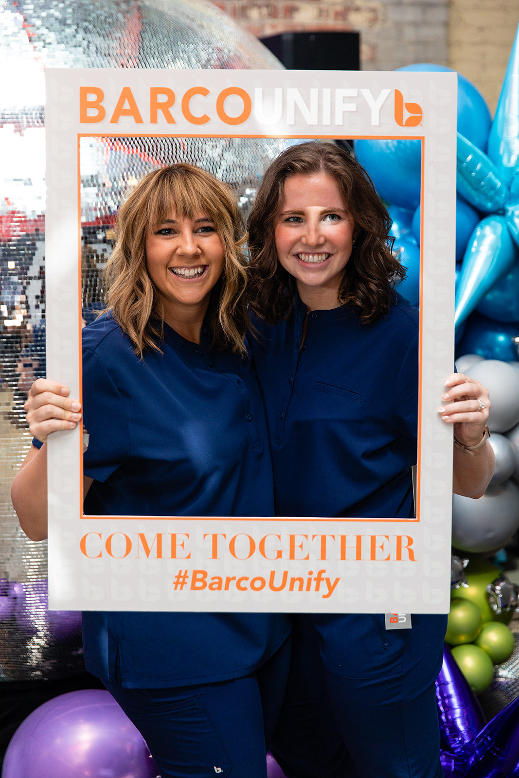 Two nurses wearing Barco Unify pose for a photo at the Nurses Inspiring Nurses event in Detroit
