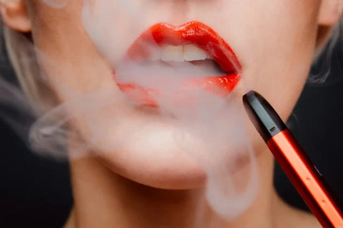 blond women vaping with red lips