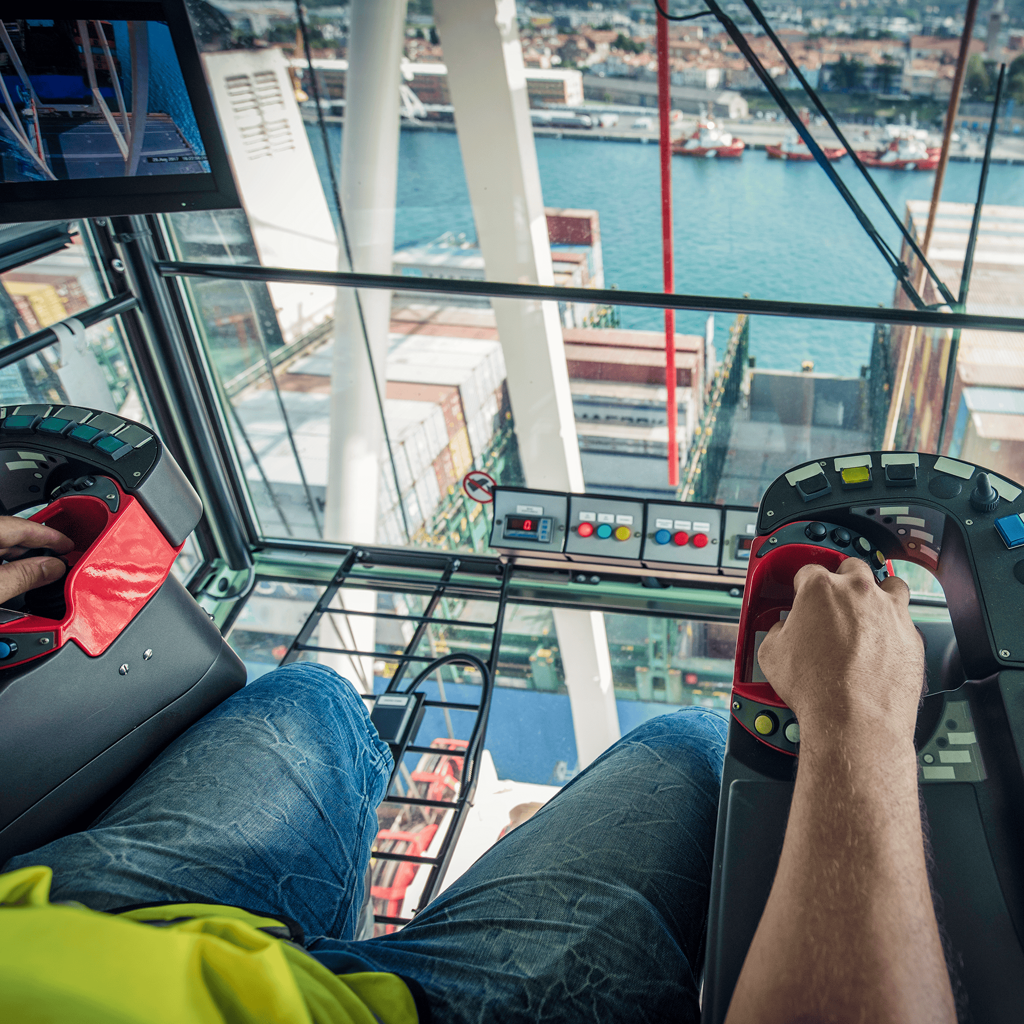 The inside of a crane cab overlooking a city
