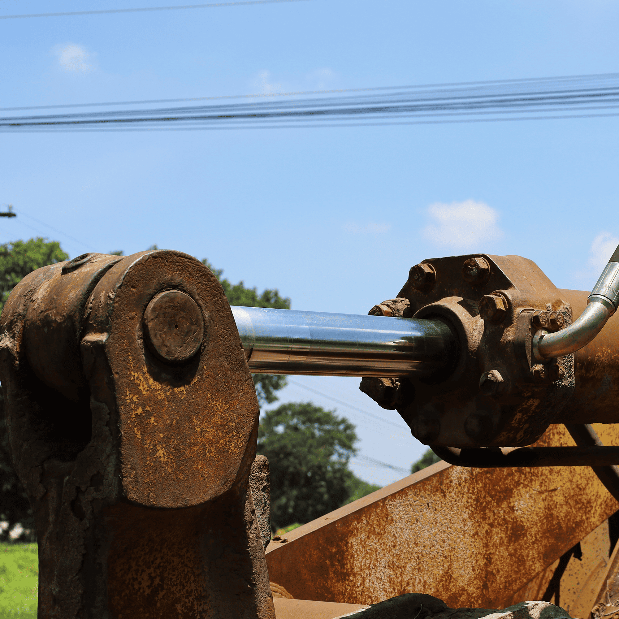 A rusty hydraulic device at the end of a piece of heavy equipment