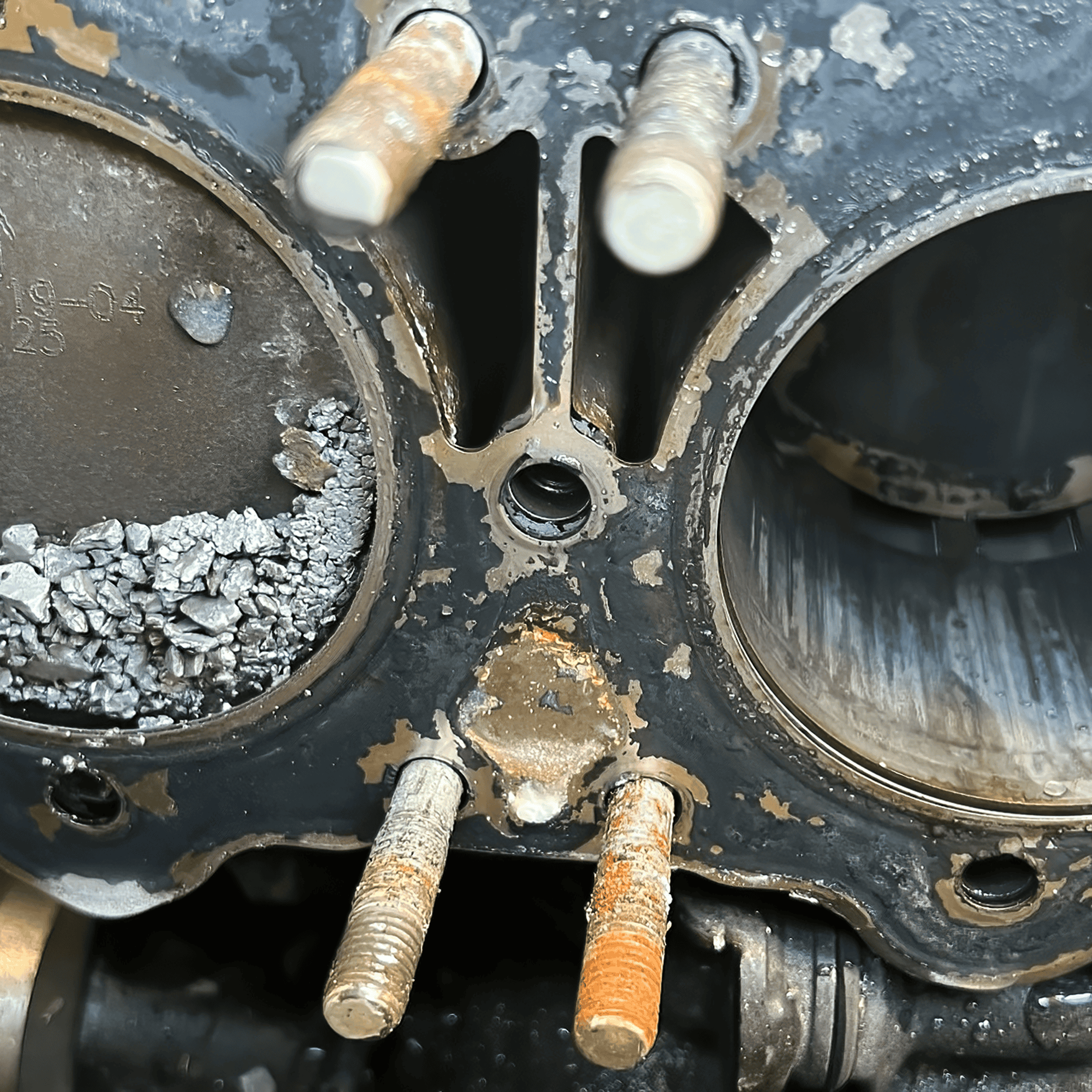 A corroded gasket seal covered in rock and dirt