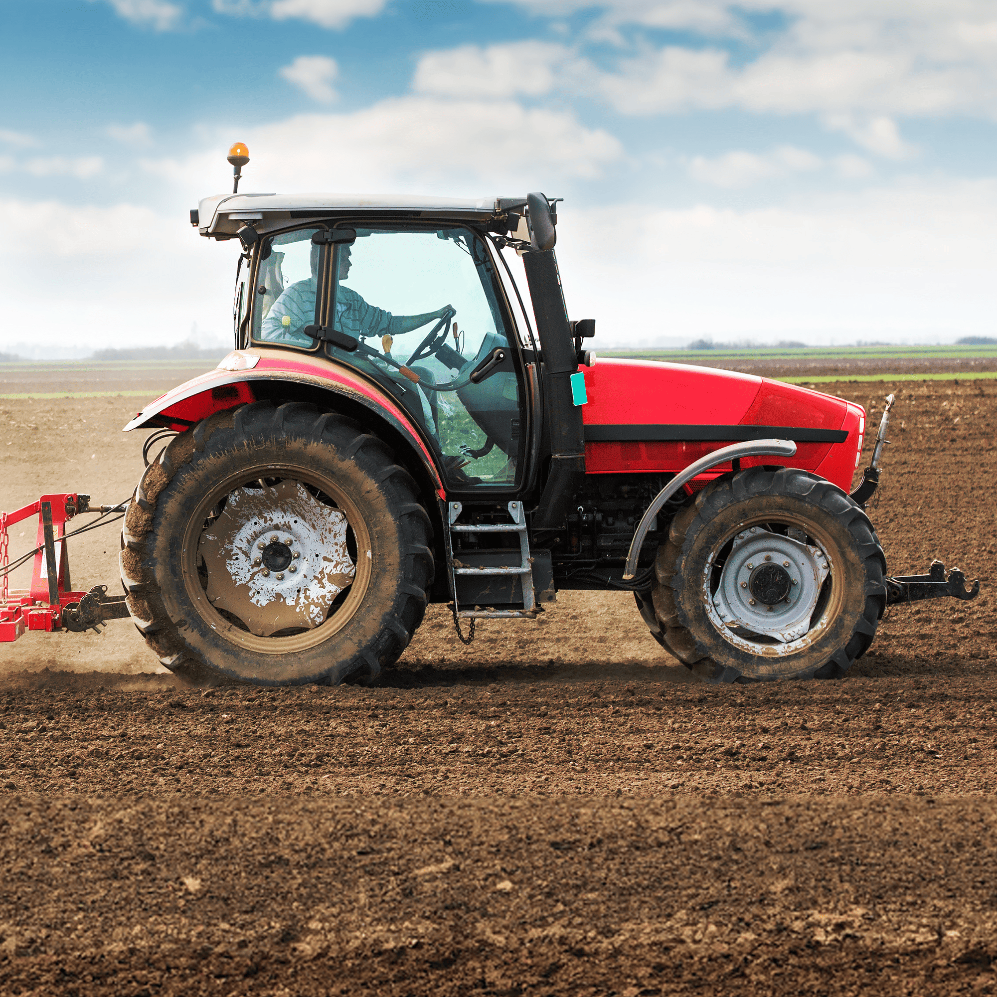 A tractor driving across a dirt field