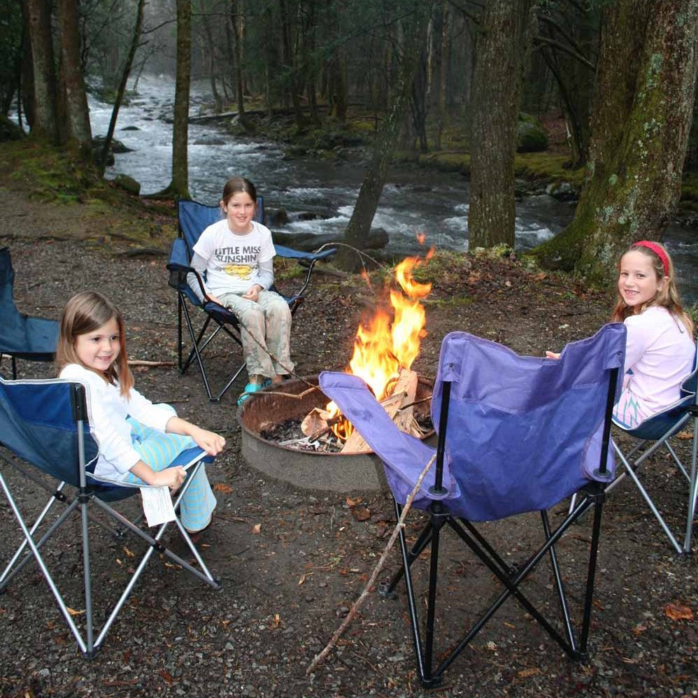 girls hanging around campfire