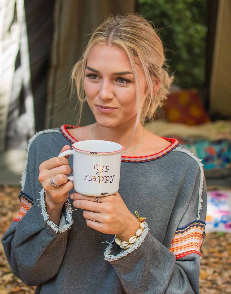 Girl holding camp mug while backyard camping