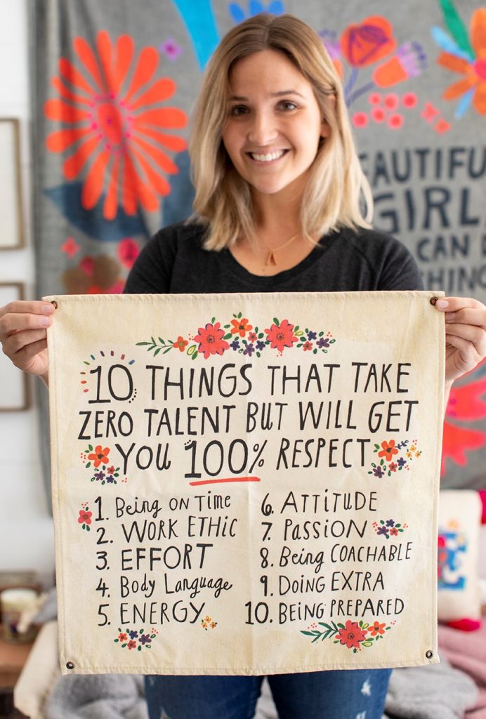 Girl holding mini canvas tapestry that lists 10 things that will get you respect. We love teachers and this makes the perfect gift for them for their classroom!