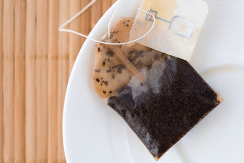 Isolated, used tea bag resting on plate