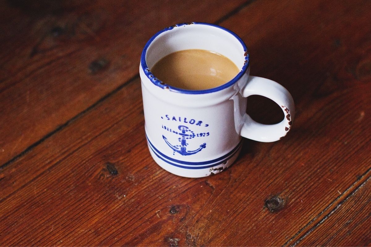 cup of black tea with milk in sailor cup