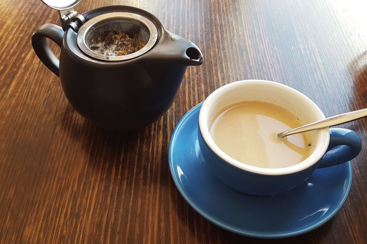 oolong tea with milk next to tea pot