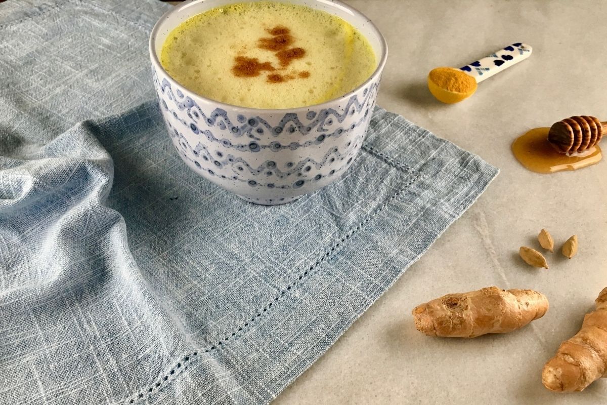 golden milk or turmeric latte against blue tablecloth