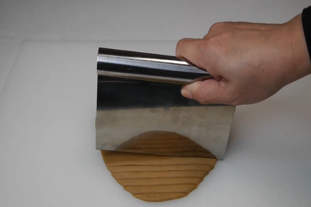 cutter cutting dough into long strips