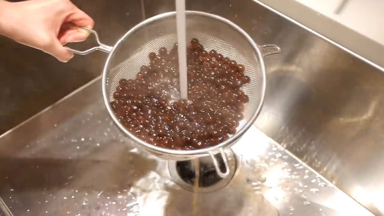 rinsing boba pearls in strainer with cold water