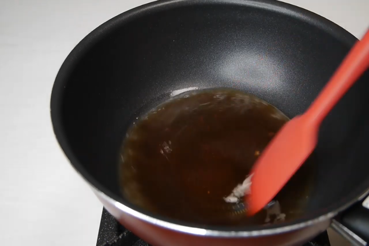 spatula stirring water and sugar in a pan