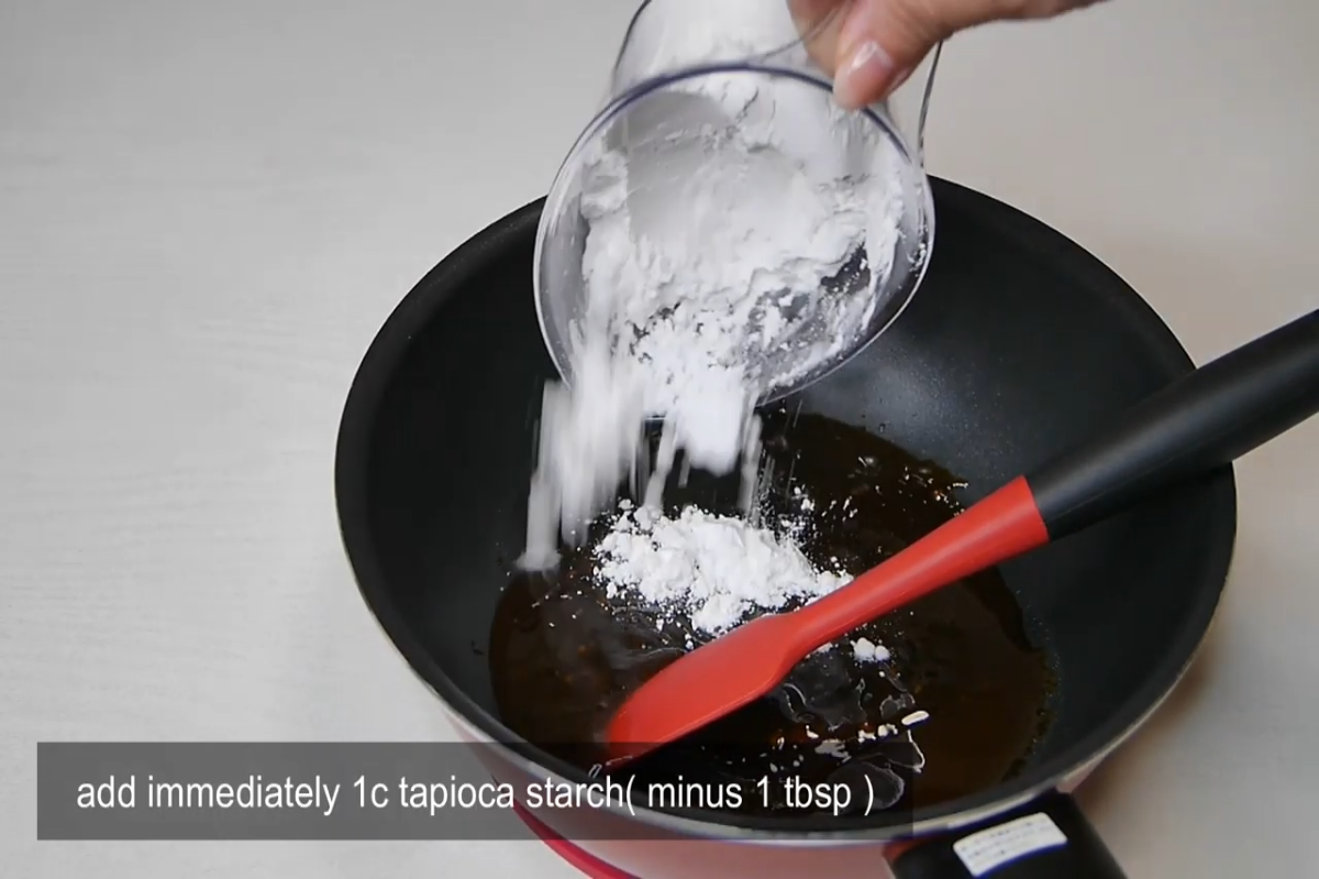 cup of tapioca starch being added to pan