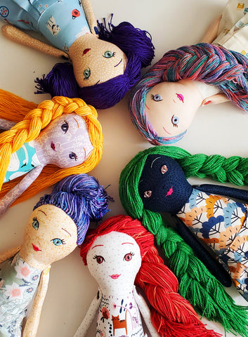 Circle of various handmade dolls with yarn hair