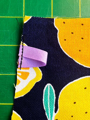 Folded ribbon sewn to fabric to be a tab on a diy zipper pouch